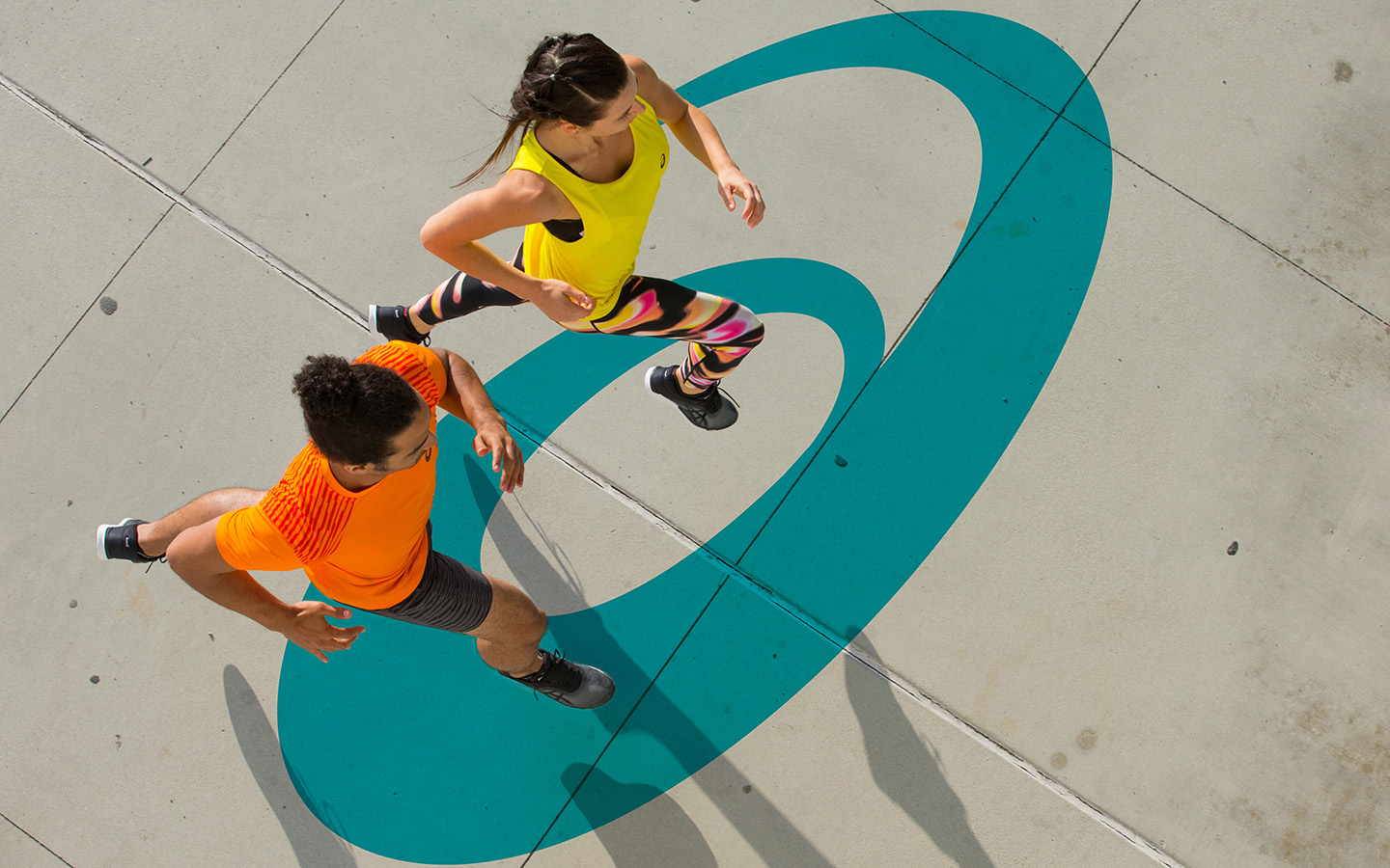 Two runners crossing an ASICS spiral mark