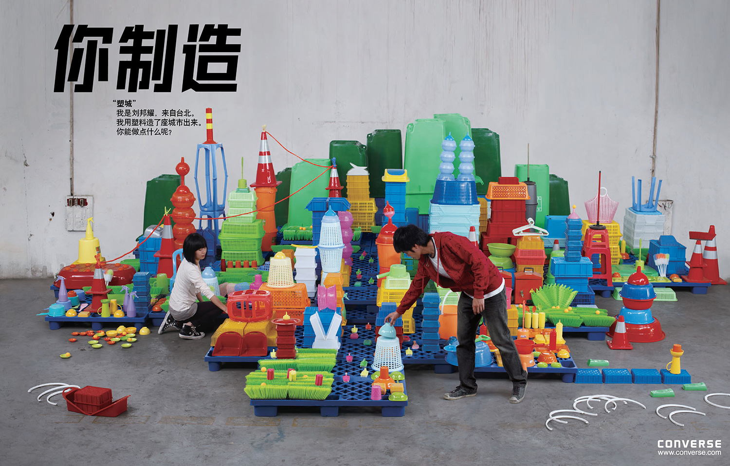 Artists assembling a colorful city from recycled plastic objects